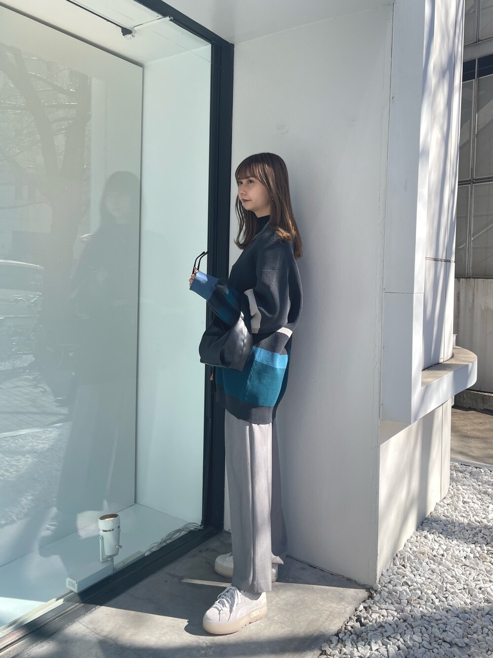 グレー系のカーディガン/ボレロ、ブラック系のニット/セーター、グレー系のスラックスを着用したレディースの冬コーディネートの3枚目の写真