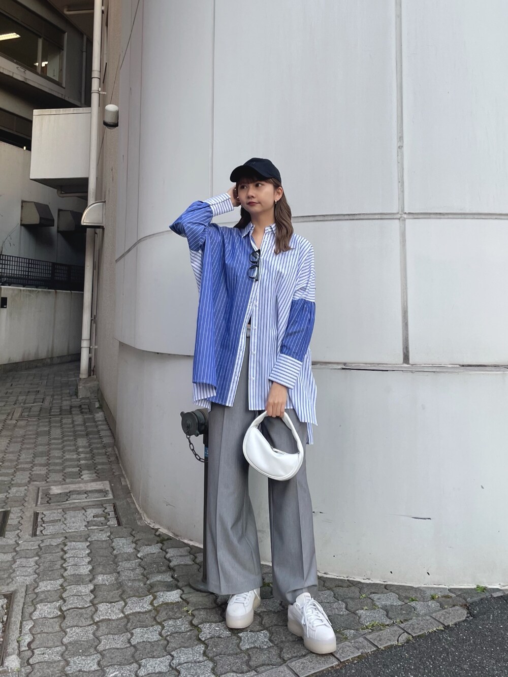 ブルー系のシャツ/ブラウス、ホワイト系のハンドバッグ、グレー系のスラックスを着用したレディースの冬コーディネートの2枚目の写真