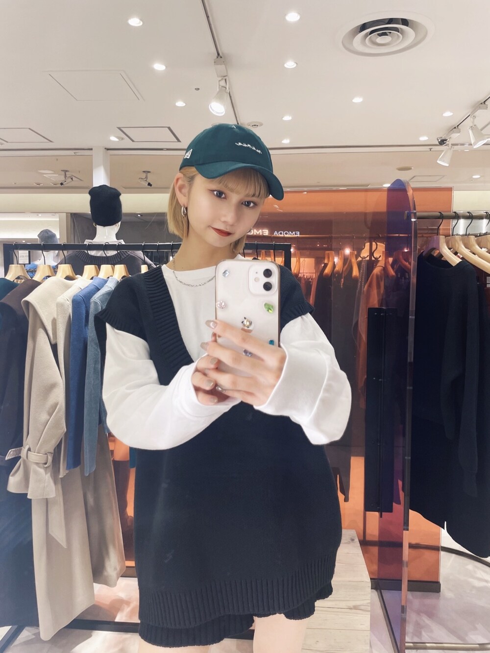 ホワイト系のTシャツ/カットソー、ブラック系のベスト、グリーン系のキャップを着用したレディースの冬コーディネートの3枚目の写真