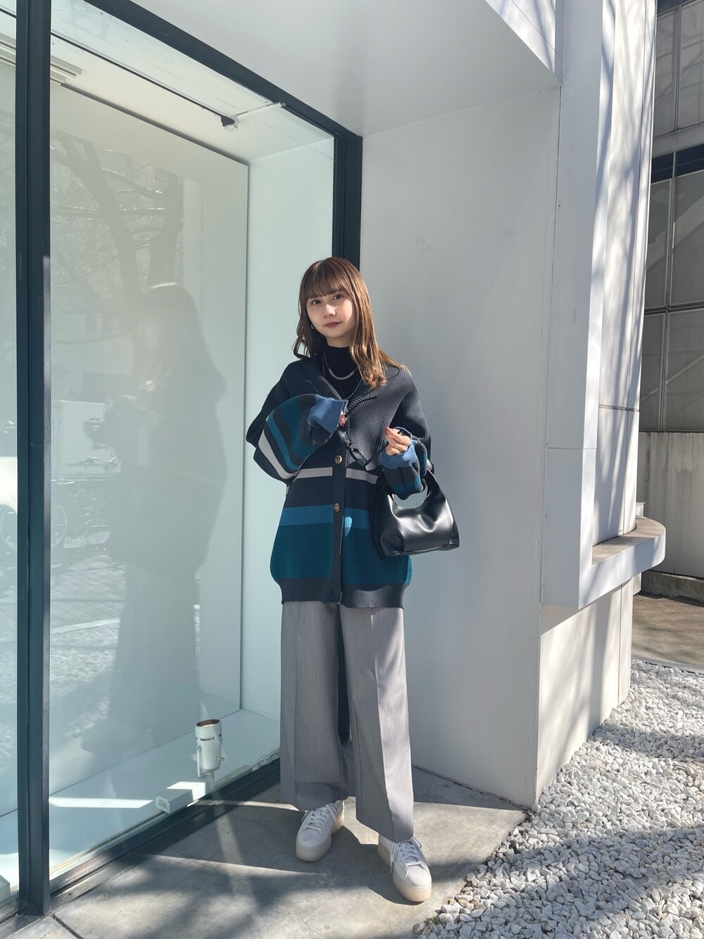 グレー系のカーディガン/ボレロ、ブラック系のニット/セーター、グレー系のスラックスを着用したレディースの冬コーディネートの2枚目の写真