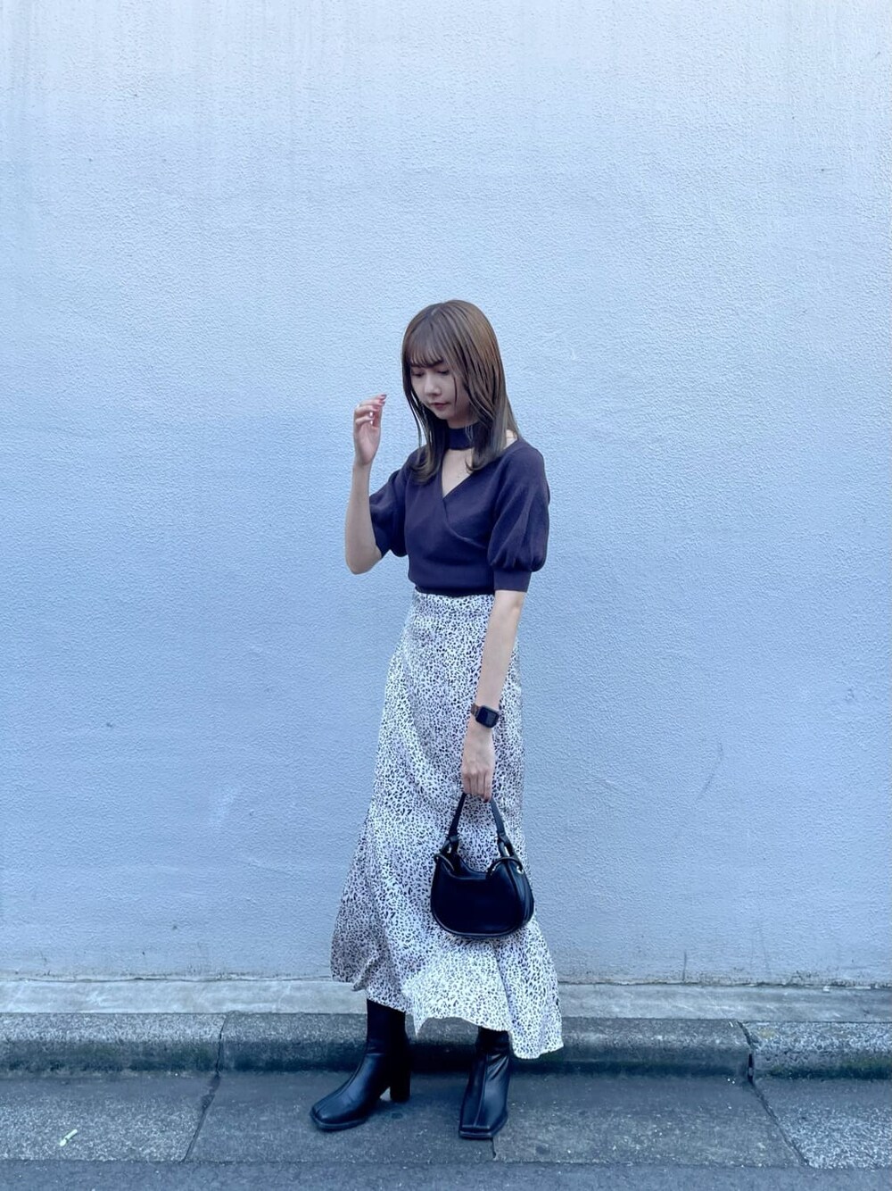 ブラック系のブーツ、ブラック系のハンドバッグ、その他のスカートを着用したレディースの夏コーディネートの2枚目の写真