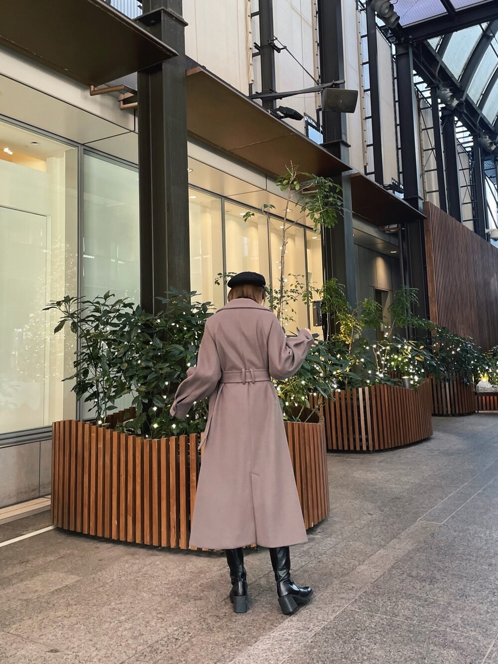 ブラウン系のステンカラーコートを着用したレディースの冬コーディネートの6枚目の写真