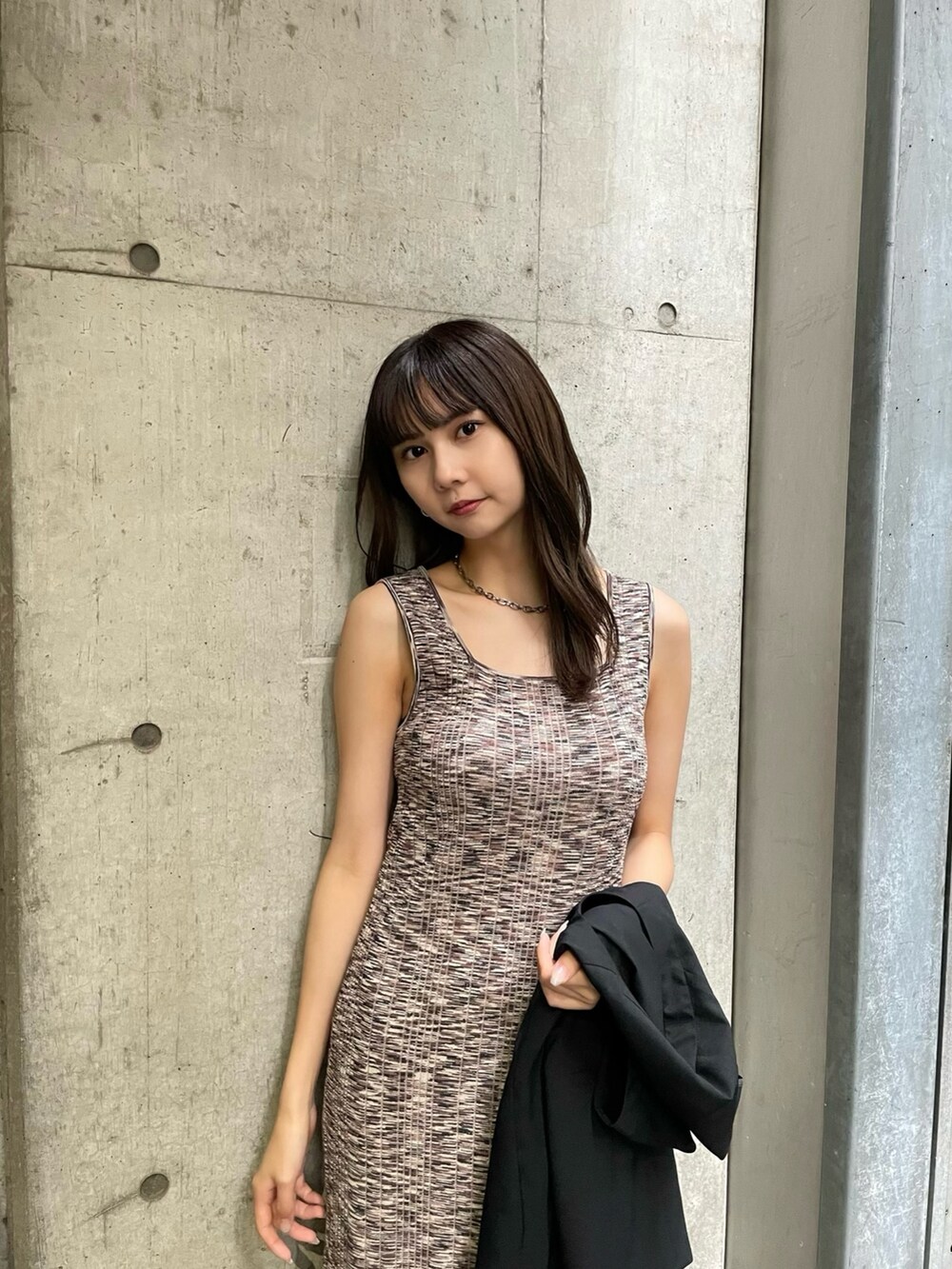 ブラック系のテーラードジャケット、ブラウン系のワンピースを着用したレディースの春コーディネートの4枚目の写真