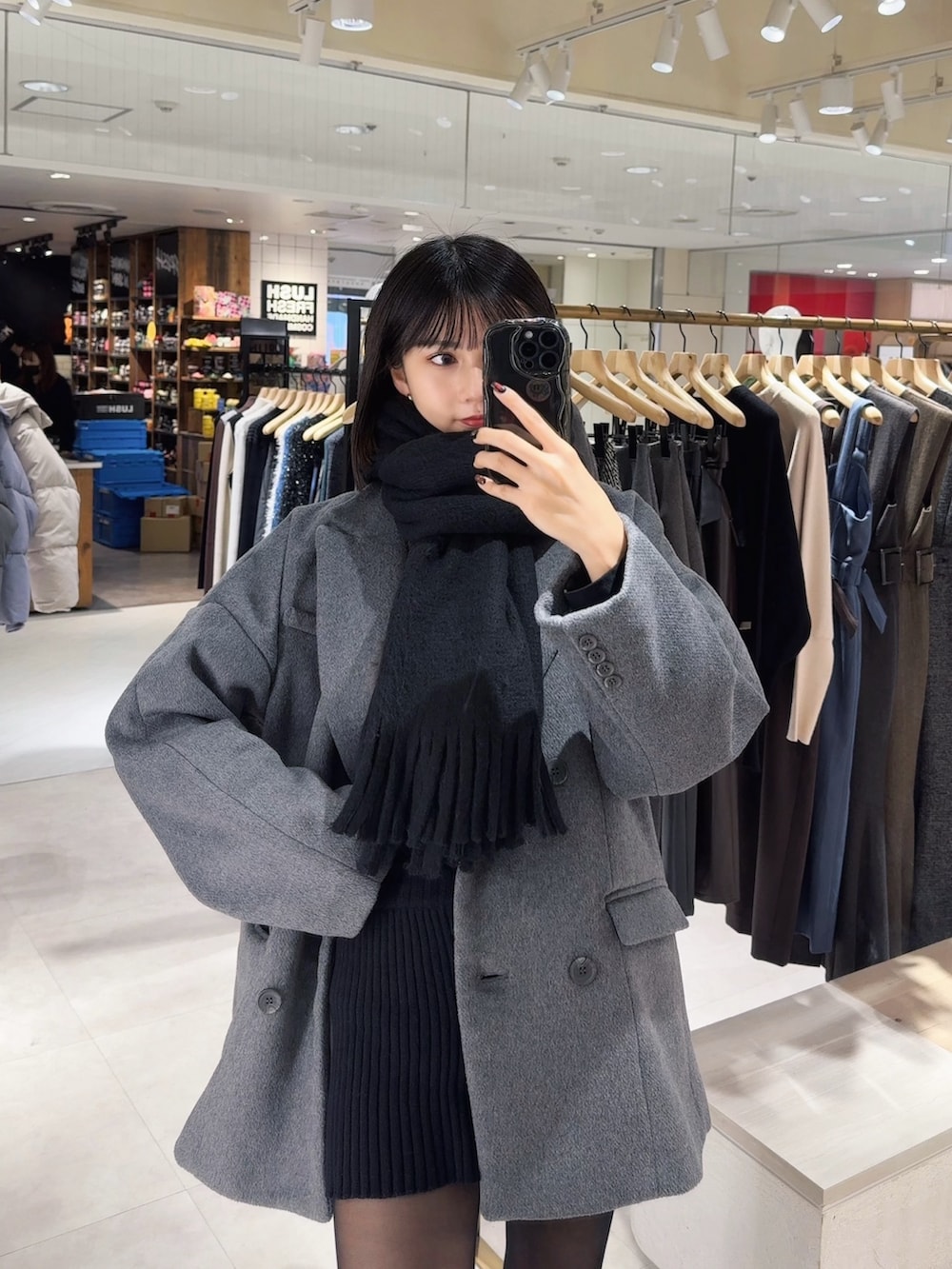 グレー系のテーラードジャケット、ブラック系のマフラーを着用したレディースの冬コーディネートの2枚目の写真