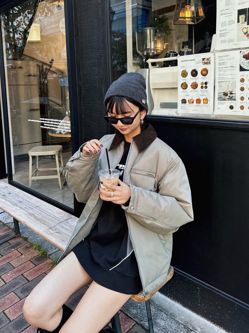 グリーン系のブルゾン、ブラック系のブーツ、ブラック系のスウェットを着用したレディースの秋コーディネートの2枚目の写真