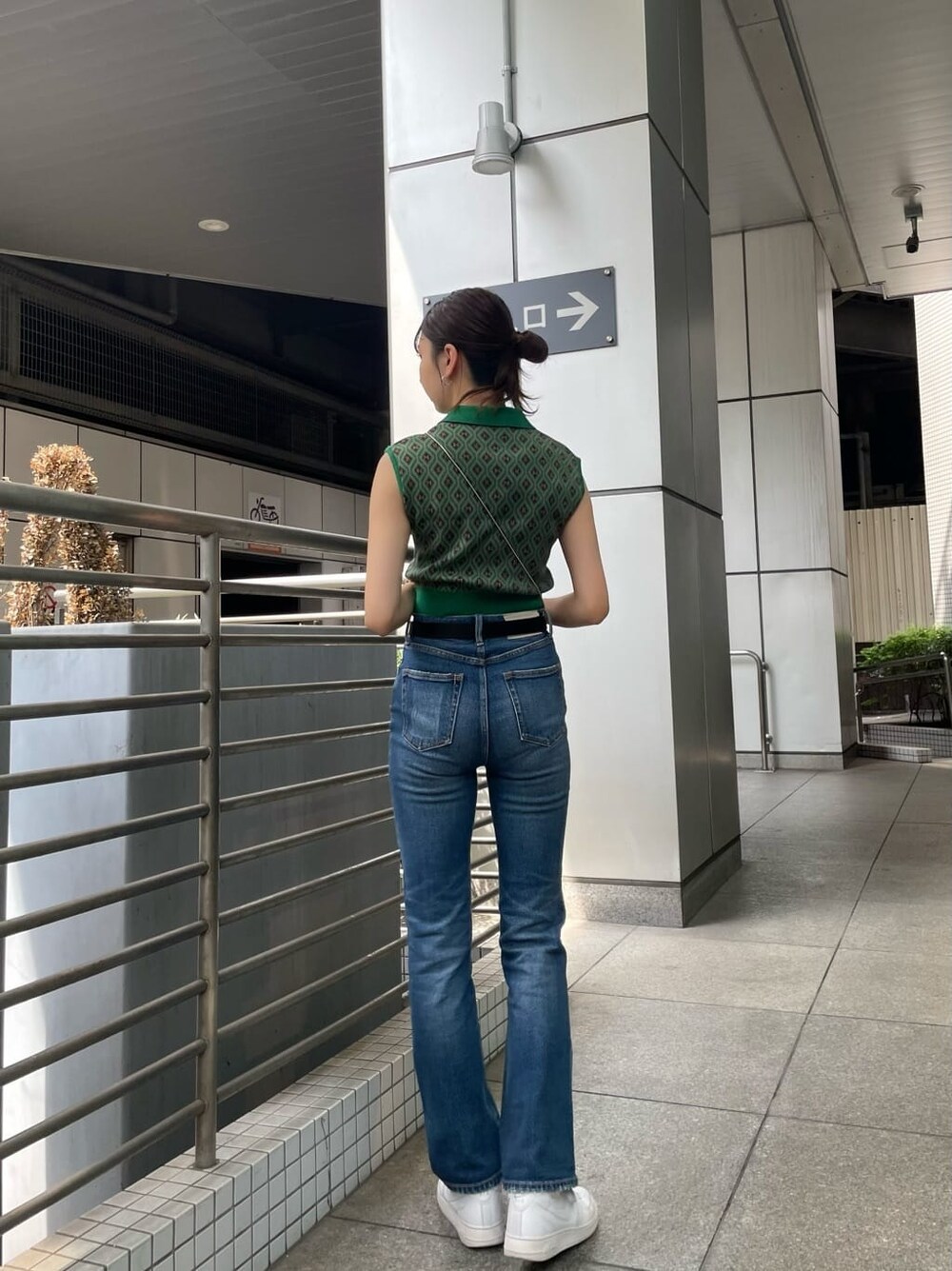 ブルー系のデニムパンツ、ブラック系のショルダーバッグ、グリーン系のニット/セーターを着用したレディースの夏コーディネートの3枚目の写真