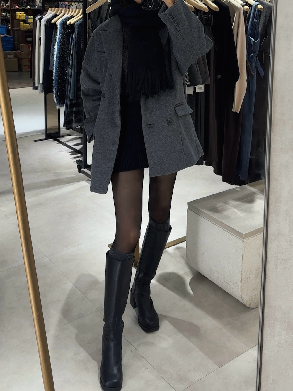 グレー系のテーラードジャケット、ブラック系のマフラーを着用したレディースの冬コーディネートの3枚目の写真