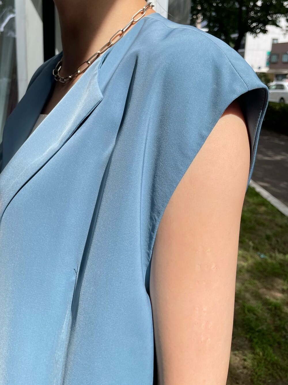 ブルー系のスカート、ブルー系のベスト、ブラック系のサンダルを着用したレディースの夏コーディネートの4枚目の写真