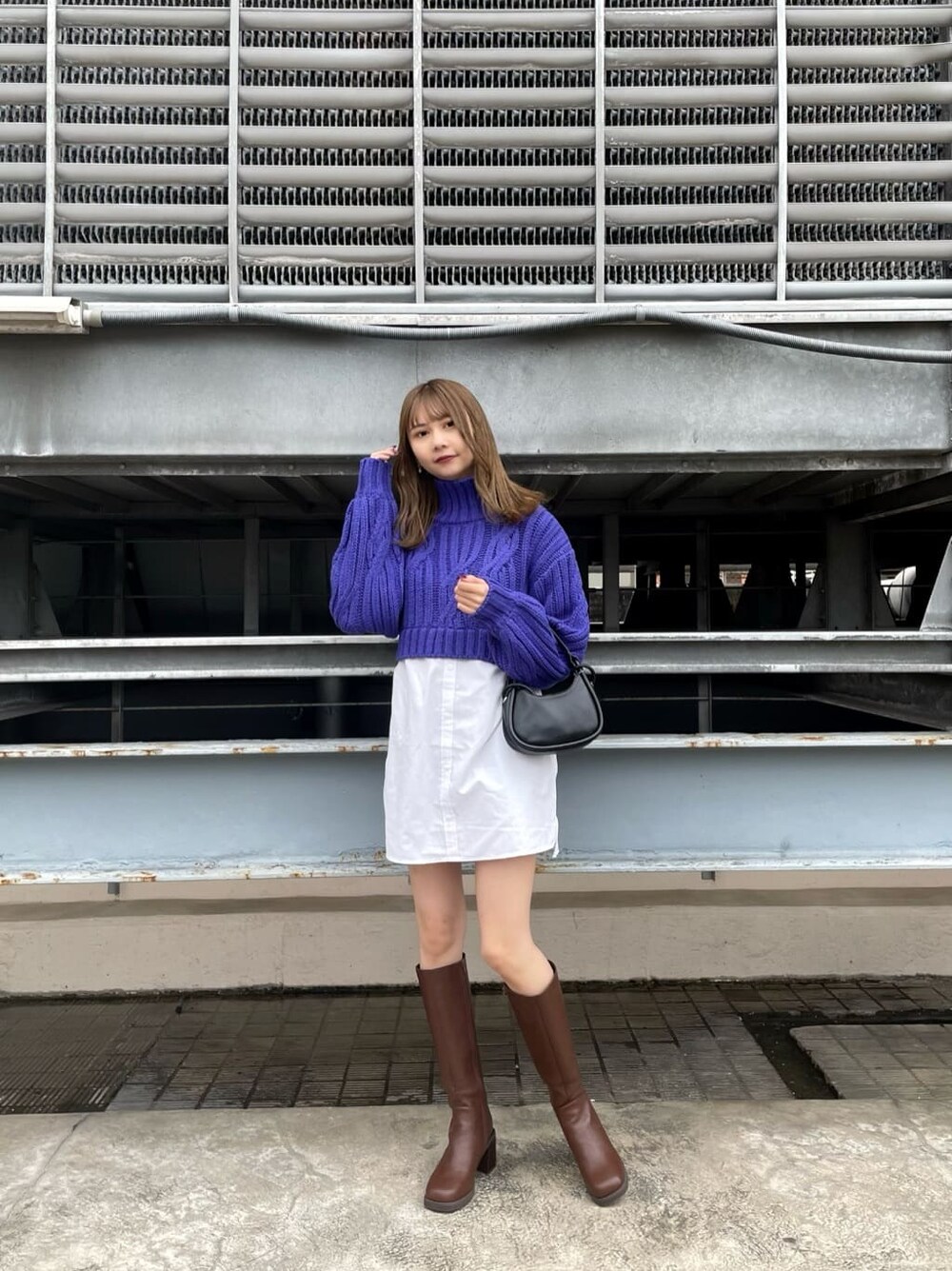 ブラウン系のムートンコート、ブラック系のハンドバッグ、ブラウン系のブーツを着用したレディースの秋コーディネートの6枚目の写真