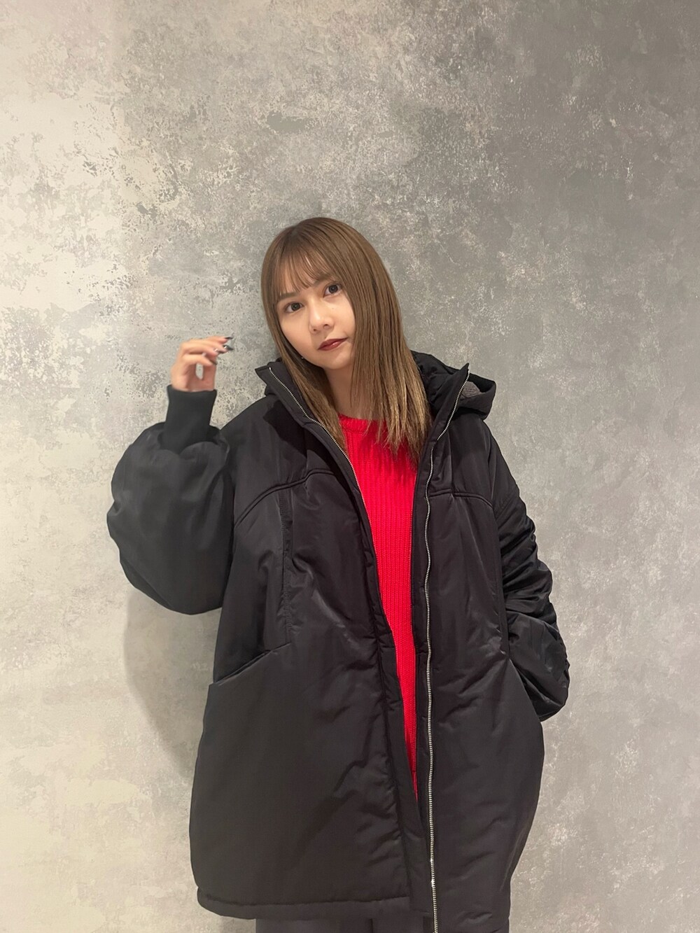 レッド系のニット/セーター、ブラック系のブルゾン、グレー系のスラックスを着用したレディースの冬コーディネートの4枚目の写真