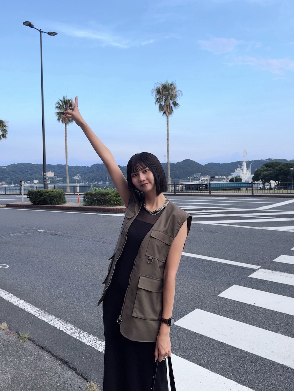 ブラック系のワンピース、グリーン系のベストを着用したレディースの秋コーディネートの2枚目の写真