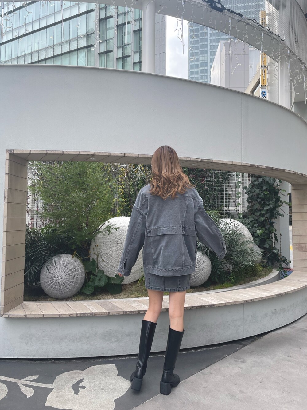 グレー系のデニムジャケット、グレー系のスカート、ブラック系のブーツを着用したレディースの冬コーディネートの5枚目の写真