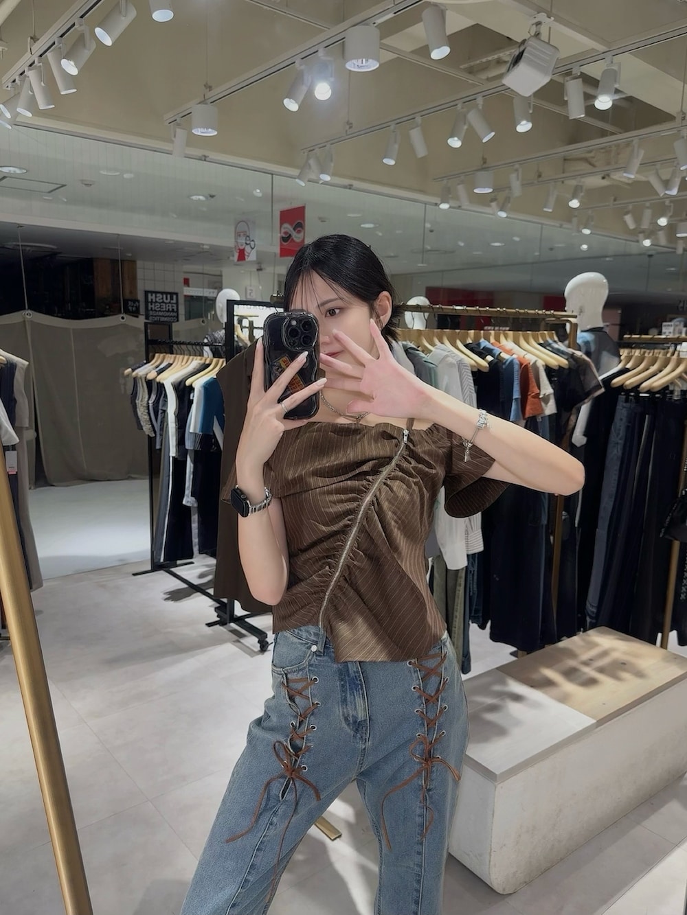 ブラウン系のシャツ/ブラウス、ブルー系のデニムパンツを着用したレディースの夏コーディネートの3枚目の写真