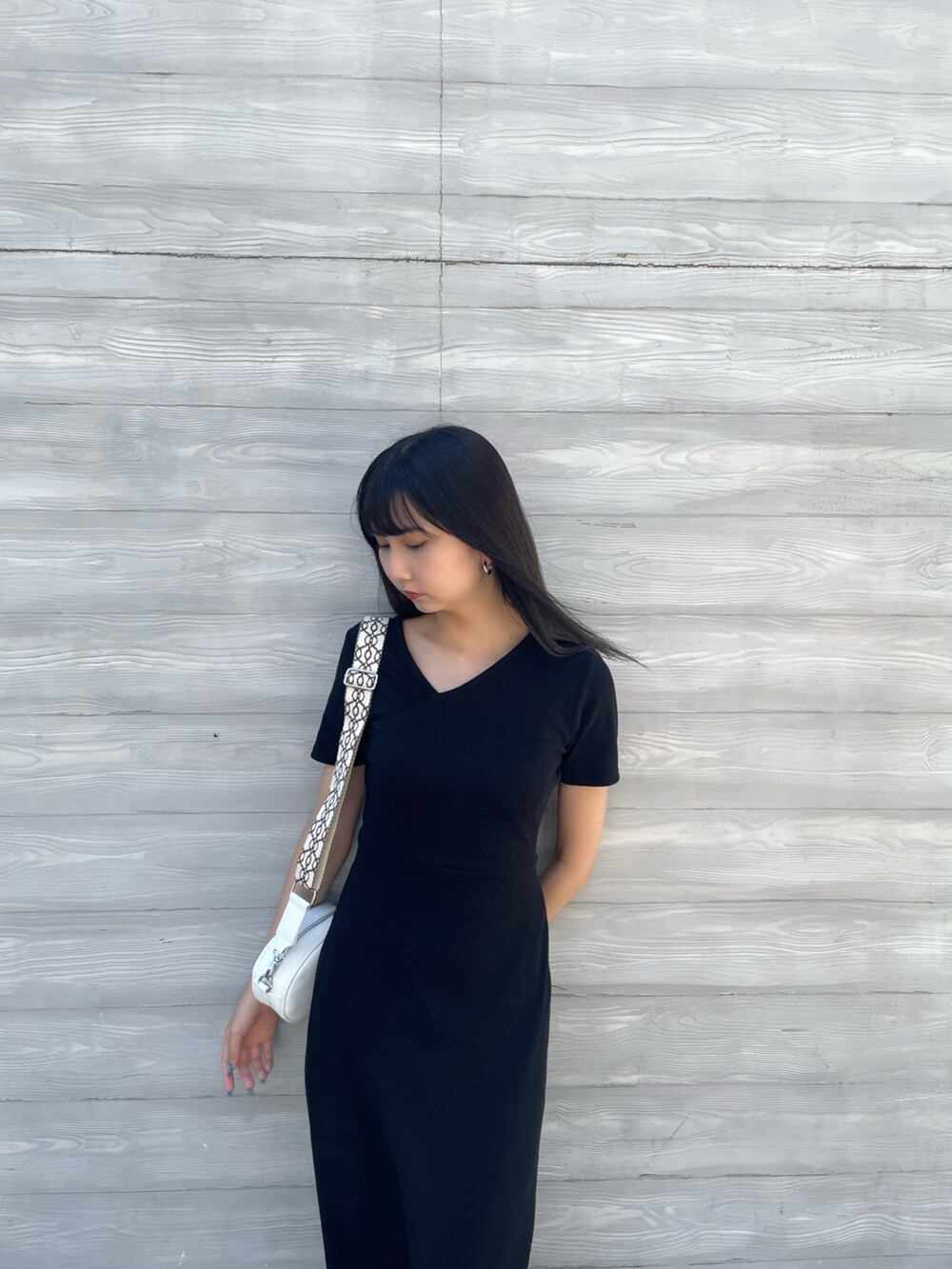 ホワイト系のショルダーバッグ、ブラック系のワンピースを着用したレディースの夏コーディネートの5枚目の写真