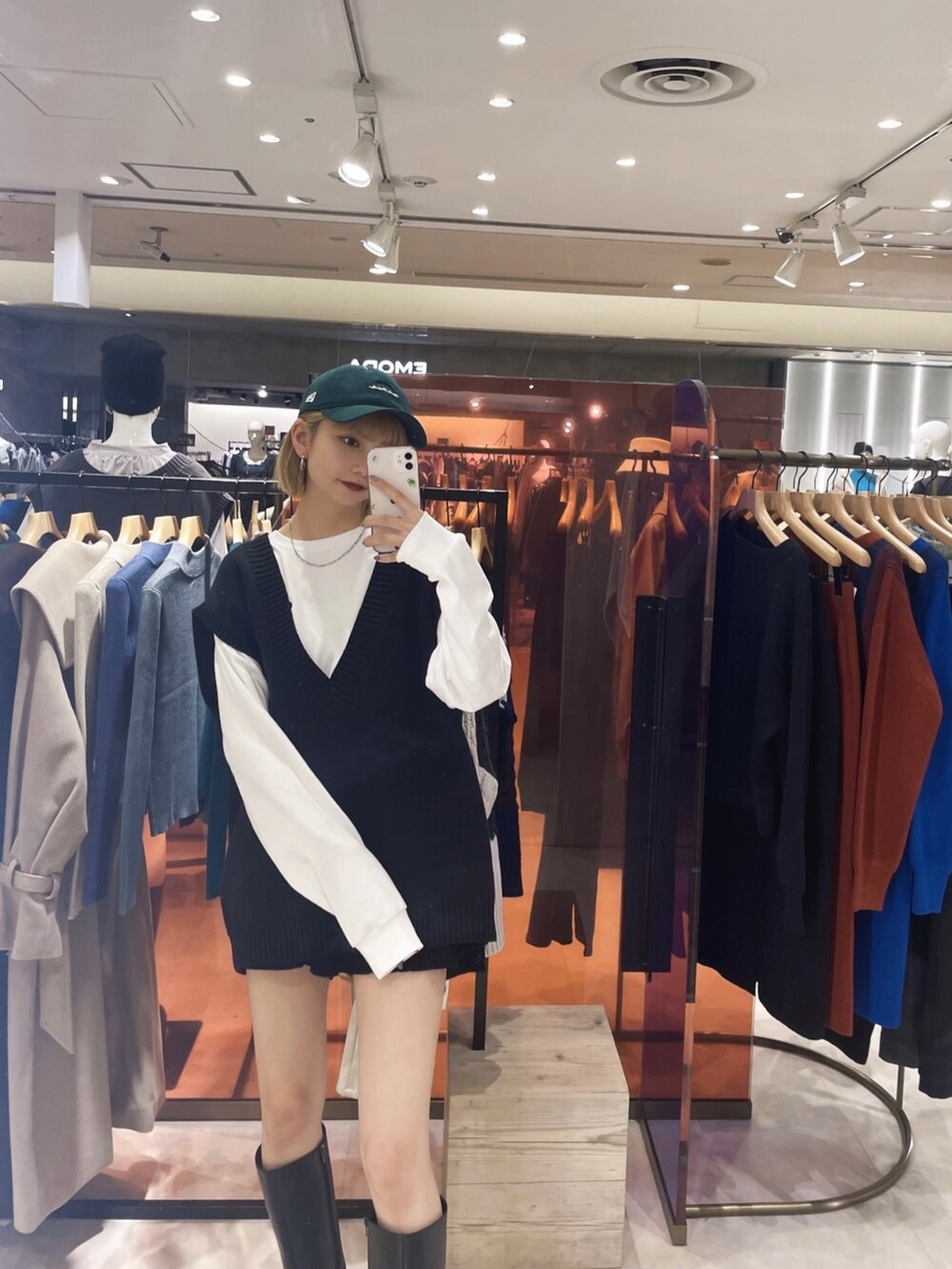 ホワイト系のTシャツ/カットソー、ブラック系のベスト、グリーン系のキャップを着用したレディースの冬コーディネートの2枚目の写真