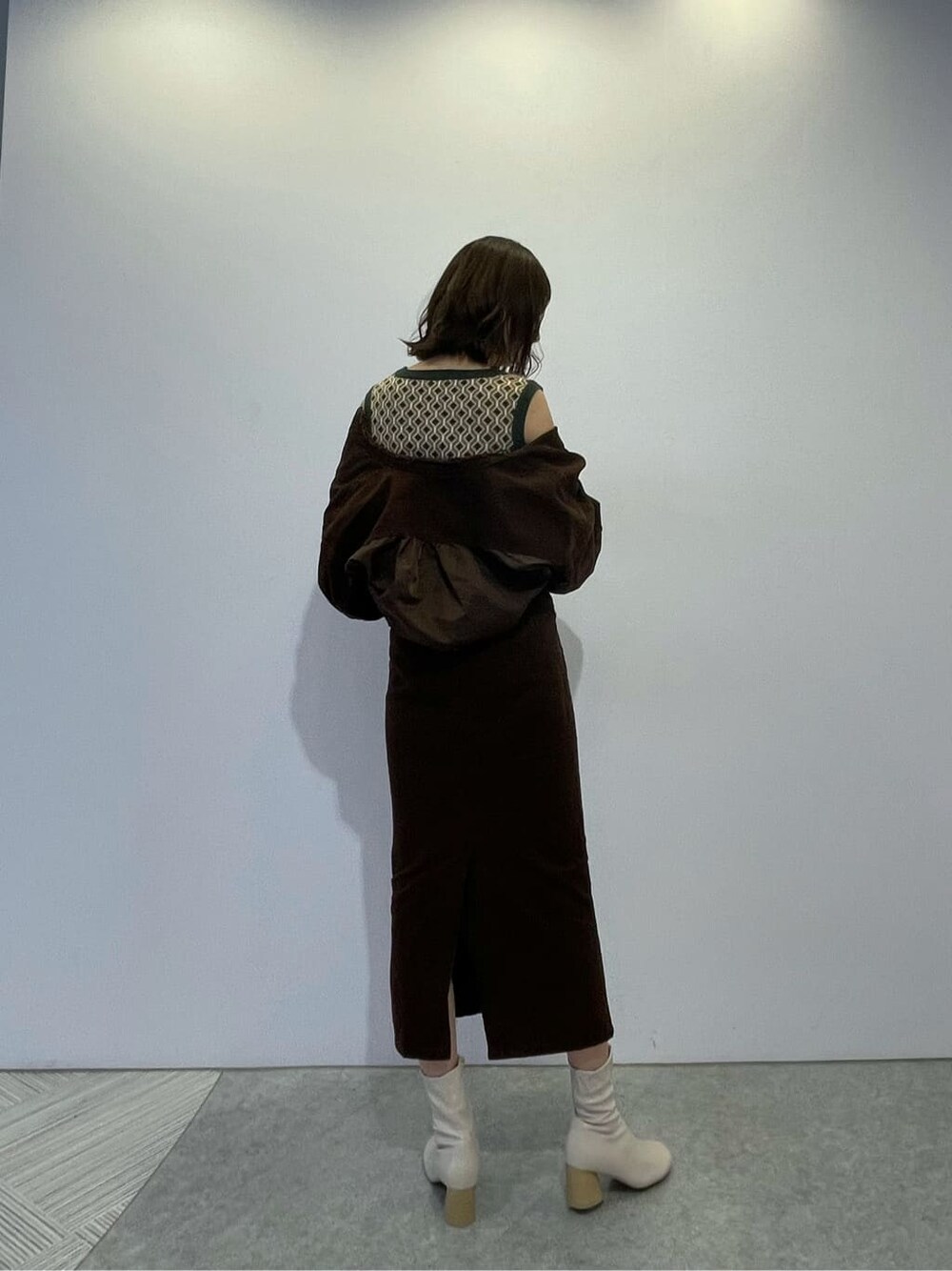 ブラウン系のブルゾン、ブラウン系のスカート、ホワイト系のブーツを着用したレディースの秋コーディネートの2枚目の写真