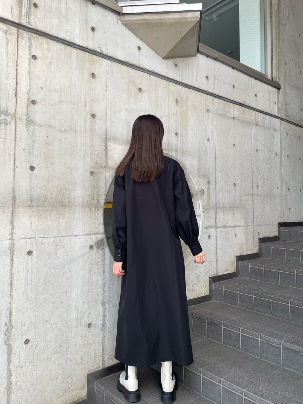 ブラック系のワンピース、ホワイト系のブーツを着用したレディースの秋コーディネートの8枚目の写真