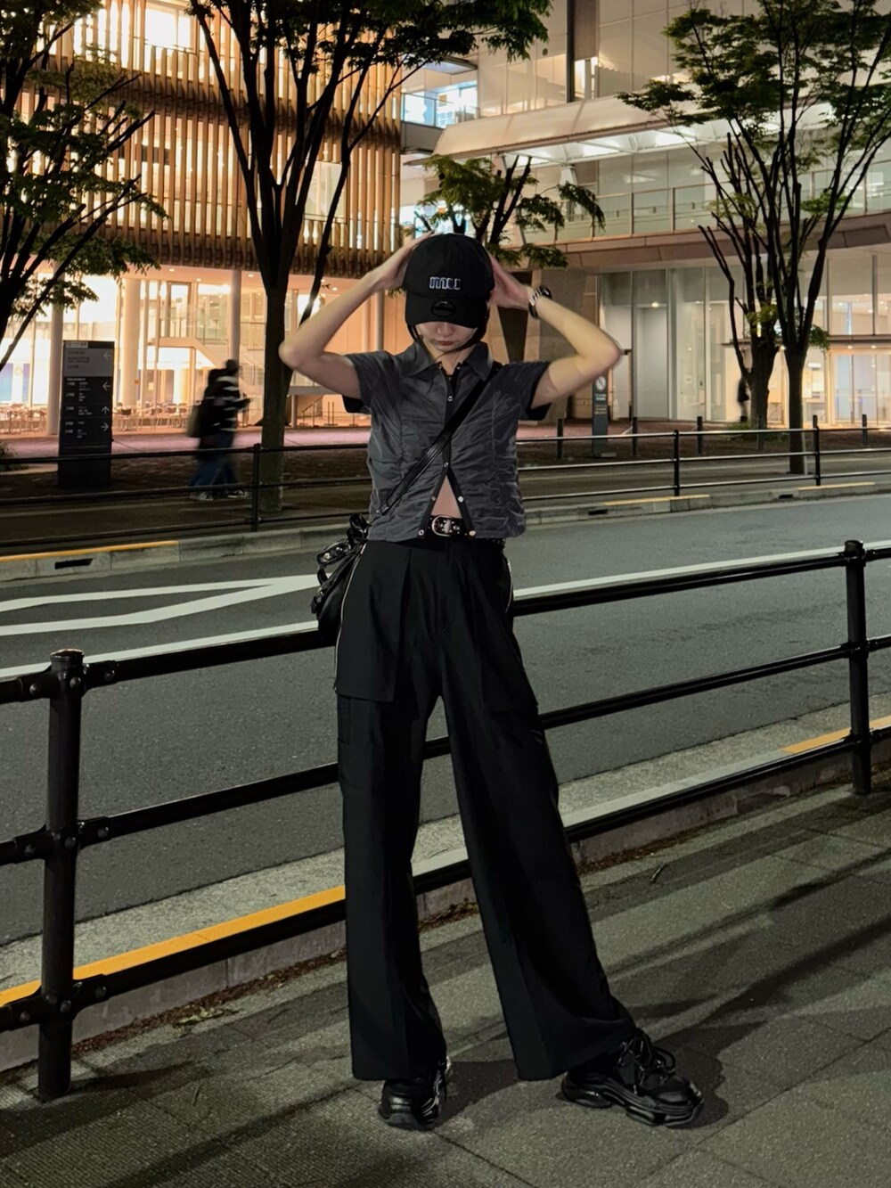 ブラック系のシャツ/ブラウス、ブラック系のスラックス、ブラック系のスニーカーを着用したレディースの春コーディネートの2枚目の写真