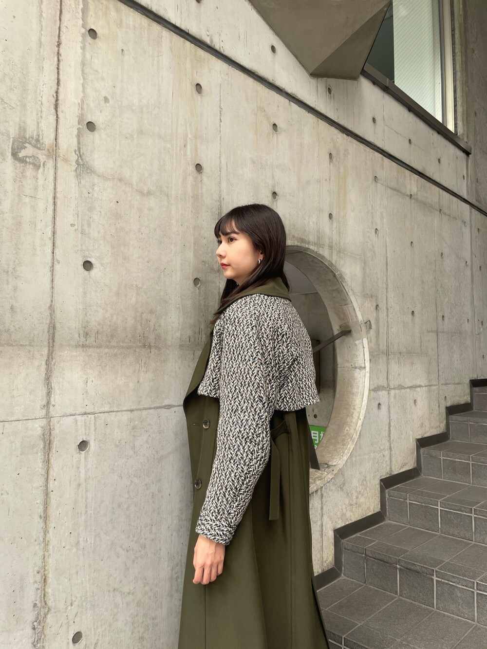 グリーン系のトレンチコートを着用したレディースの夏コーディネートの4枚目の写真