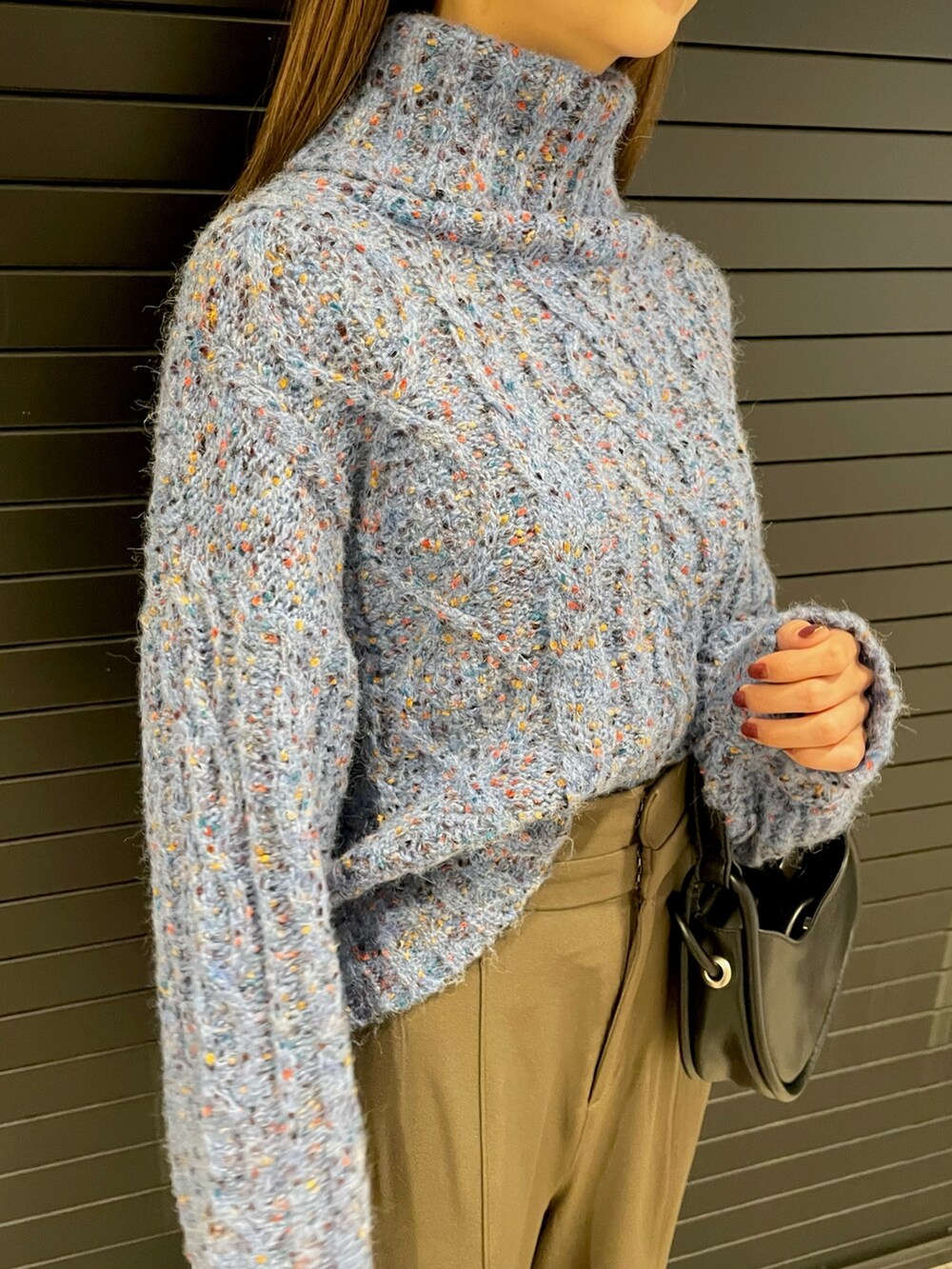 ブルー系のニット/セーター、ブラック系のハンドバッグ、ブラック系のブーツを着用したレディースの冬コーディネートの5枚目の写真