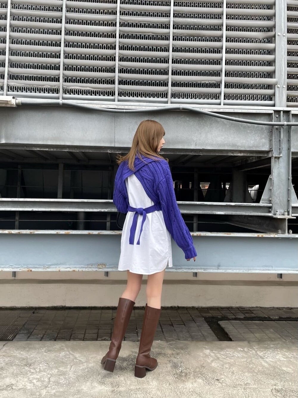 ブラウン系のムートンコート、ブラック系のハンドバッグ、ブラウン系のブーツを着用したレディースの秋コーディネートの7枚目の写真