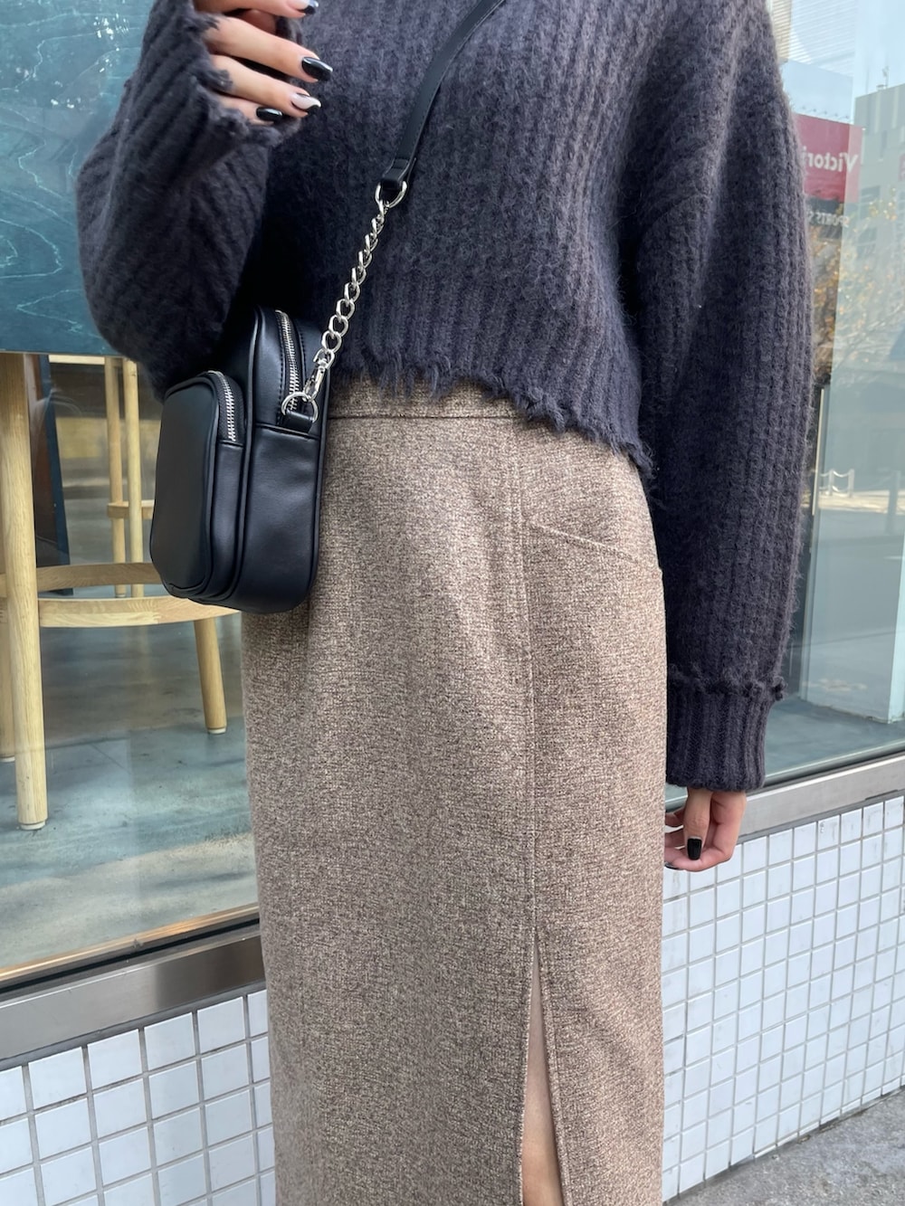 グレー系のニット/セーター、ブラウン系のスカート、ブラック系のブーツを着用したレディースの秋コーディネートの5枚目の写真