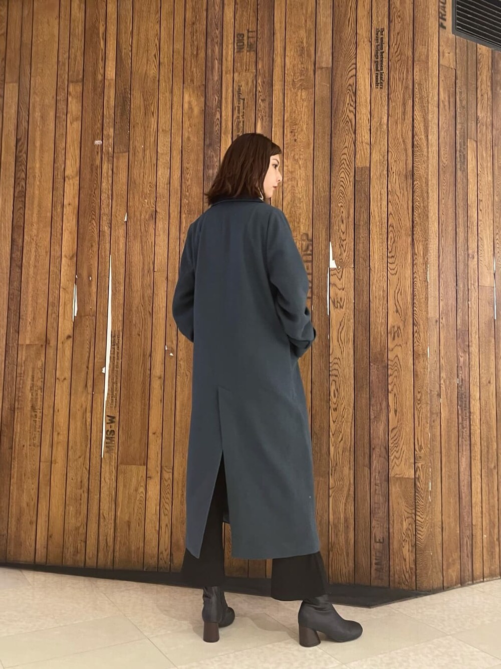 ブラック系のブーツ、ブラック系のその他パンツ、ホワイト系のハンドバッグを着用したレディースの秋コーディネートの3枚目の写真