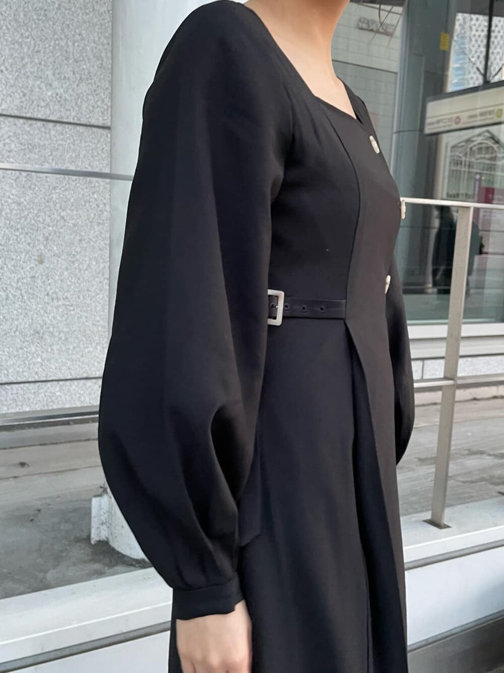 ブラック系のワンピース、ブラック系のブーツ、グレー系のブルゾンを着用したレディースの春コーディネートの6枚目の写真