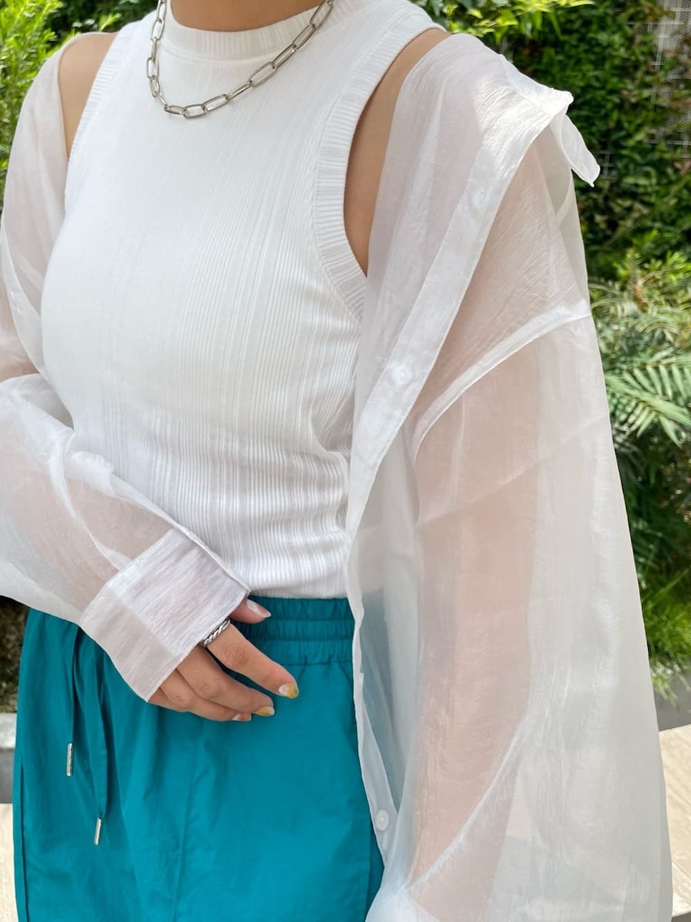 ブラック系のハンドバッグ、ホワイト系のシャツ/ブラウス、ブラック系のサンダルを着用したレディースの夏コーディネートの6枚目の写真