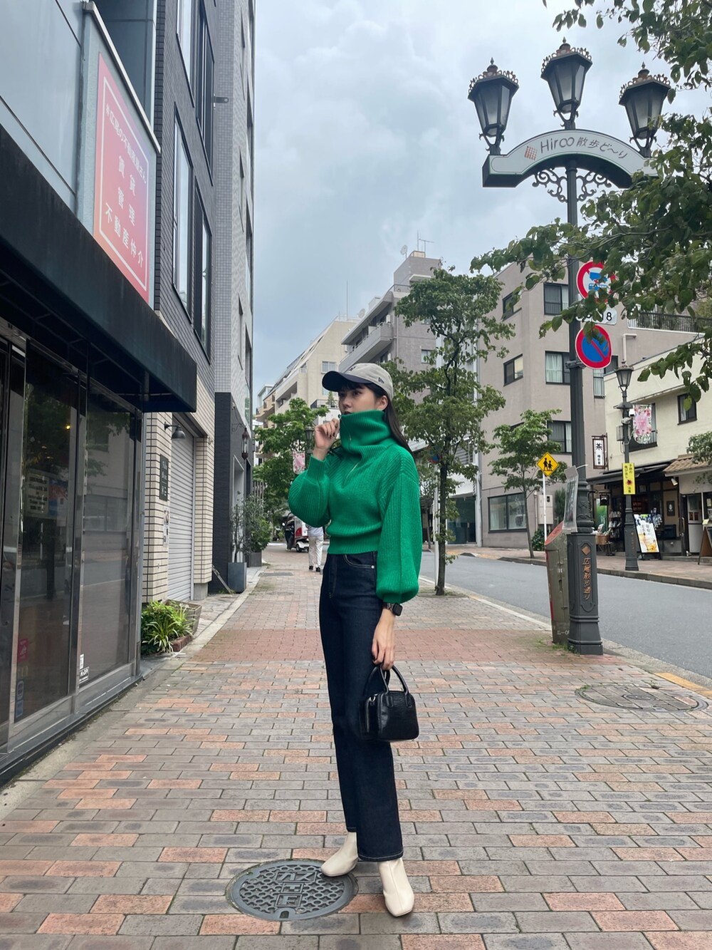グリーン系のニット/セーター、ホワイト系のブーツを着用したレディースの夏コーディネートの3枚目の写真