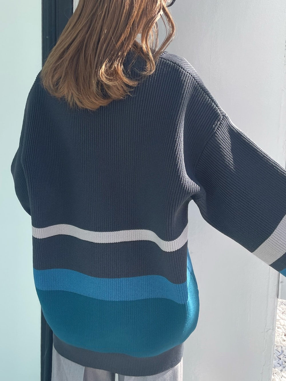 グレー系のカーディガン/ボレロ、ブラック系のニット/セーター、グレー系のスラックスを着用したレディースの冬コーディネートの5枚目の写真