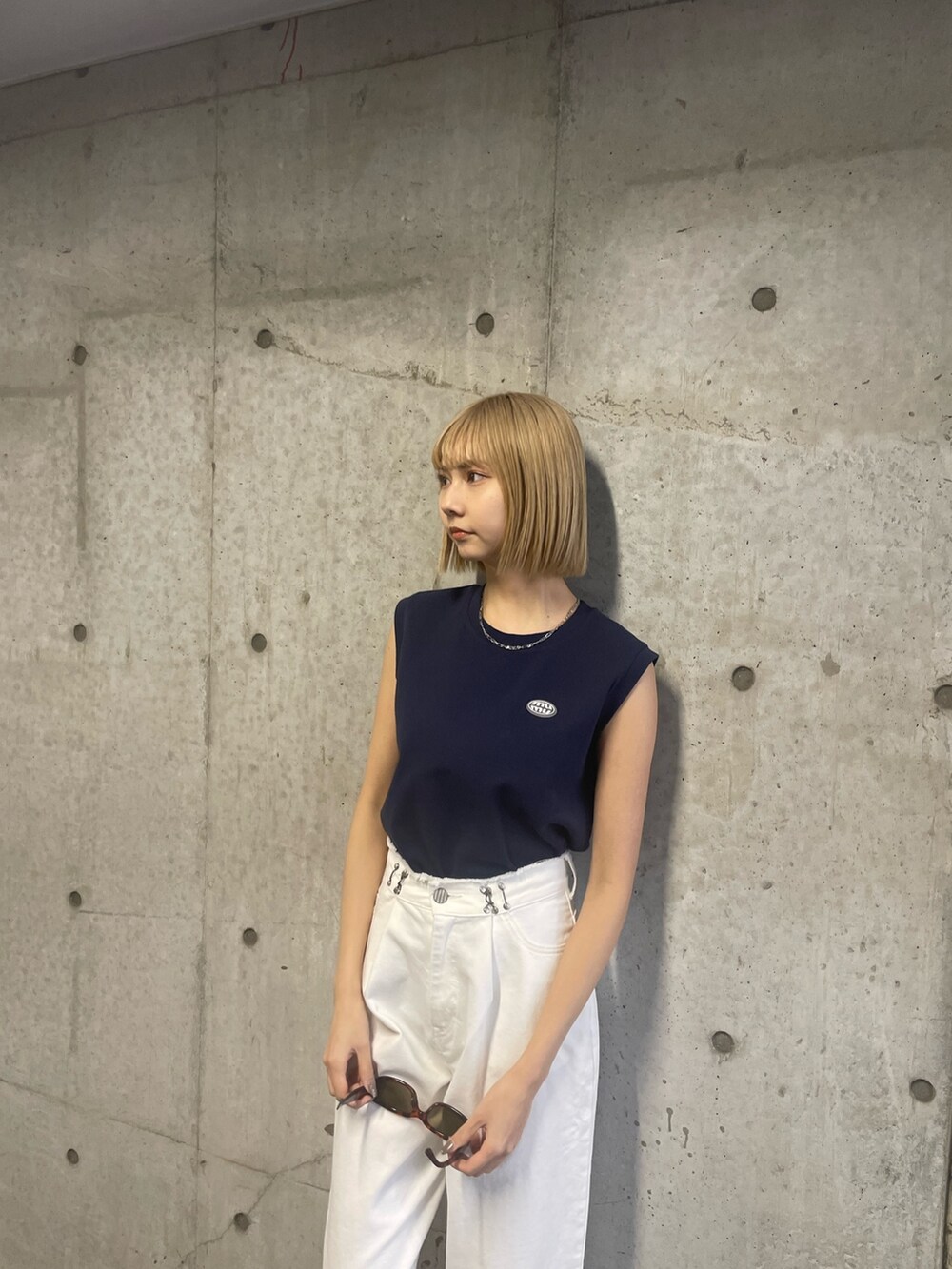 ブルー系のタンクトップ、ホワイト系のデニムパンツを着用したレディースの冬コーディネートの4枚目の写真