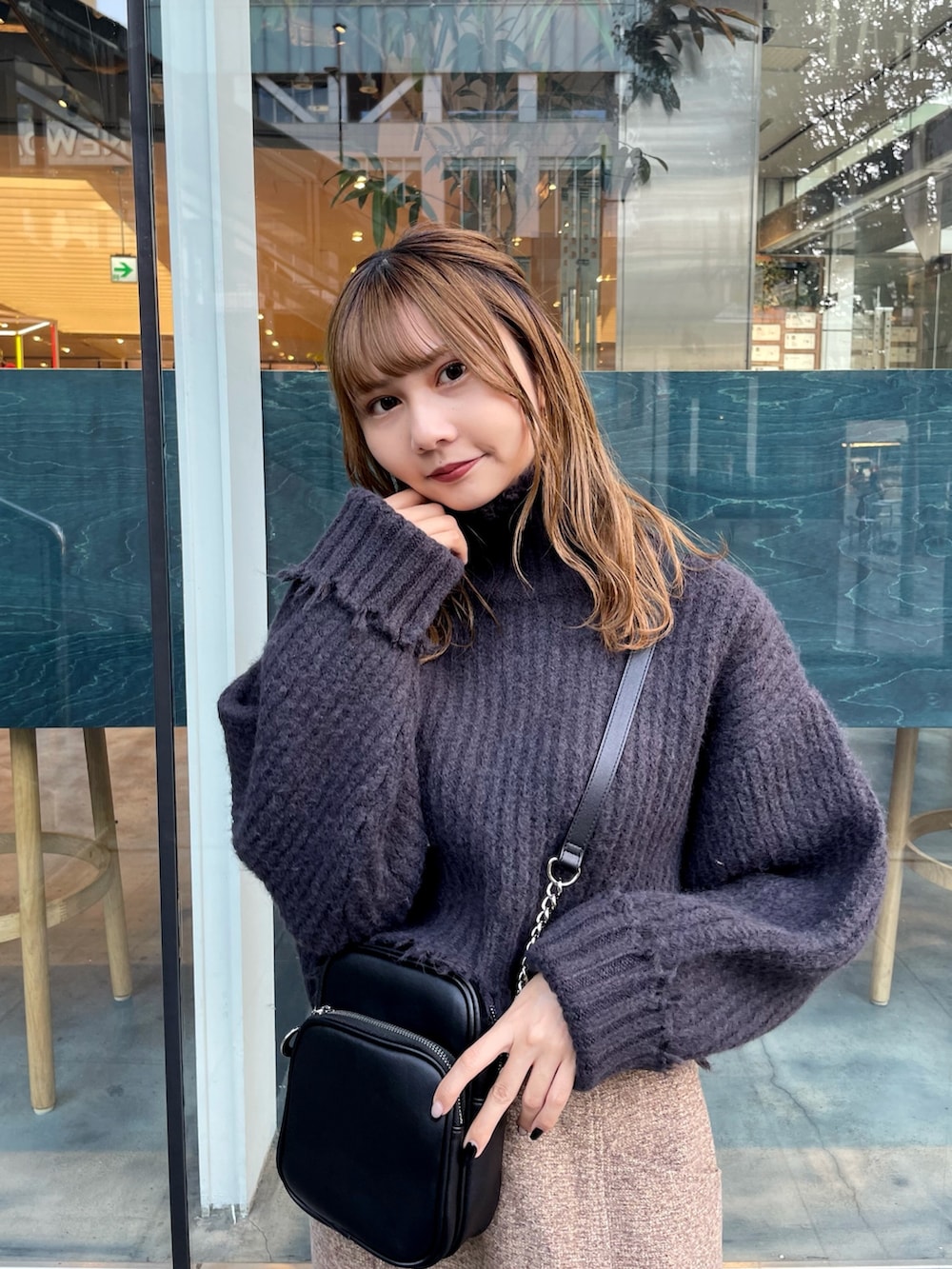 グレー系のニット/セーター、ブラウン系のスカート、ブラック系のブーツを着用したレディースの秋コーディネートの2枚目の写真