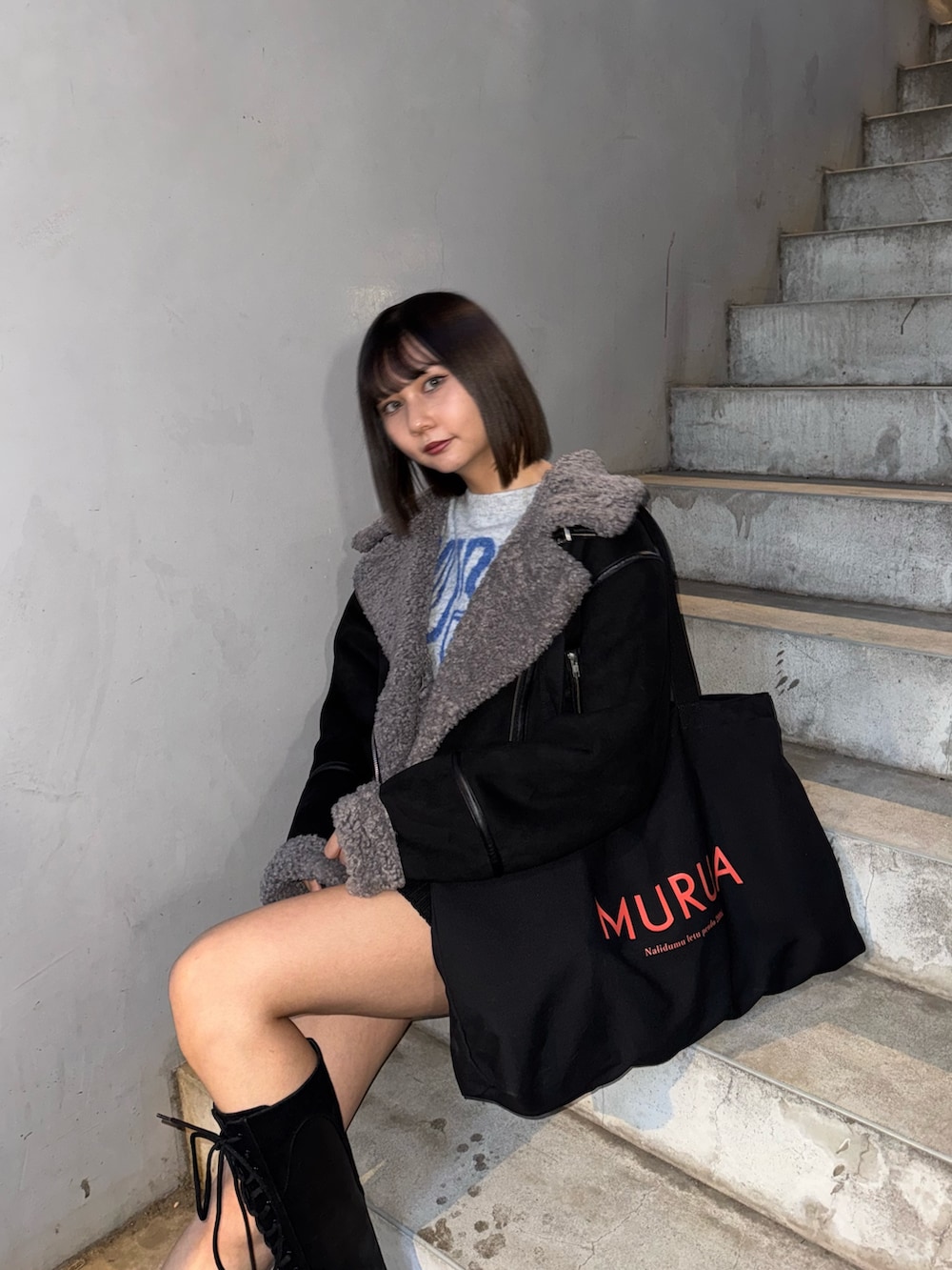 ブラック系のハンドバッグ、グレー系のニット/セーター、ブラック系のムートンコートを着用したレディースの冬コーディネートの5枚目の写真