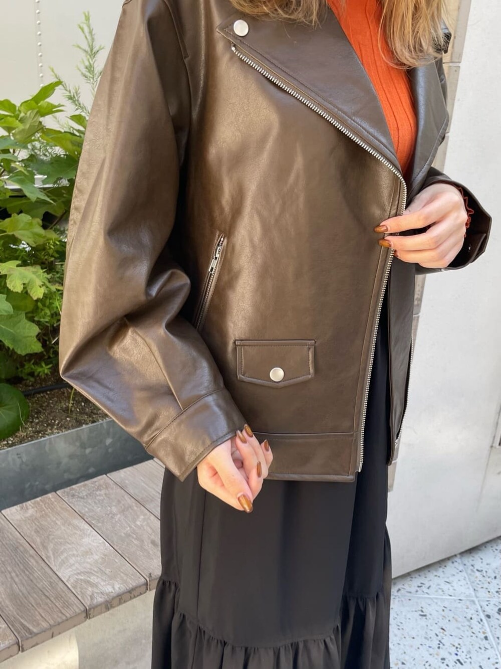 ブラック系のスカート、オレンジ系のニット/セーター、ブラック系のブーツを着用したレディースの秋コーディネートの7枚目の写真