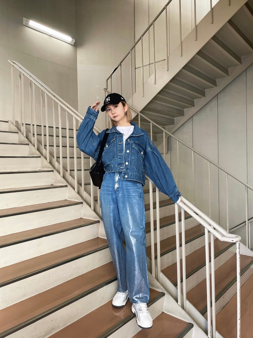 グレー系のスニーカー、ブルー系のデニムパンツ、ブルー系のデニムジャケットを着用したレディースの冬コーディネートの2枚目の写真