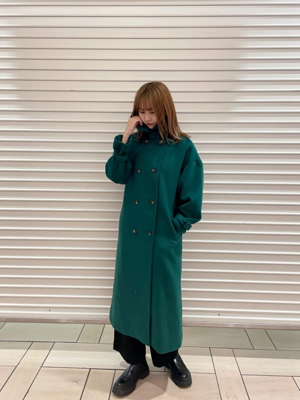 ブラック系のスラックス、ブラック系のニット/セーター、グリーン系のステンカラーコートを着用したレディースの夏コーディネートの3枚目の写真