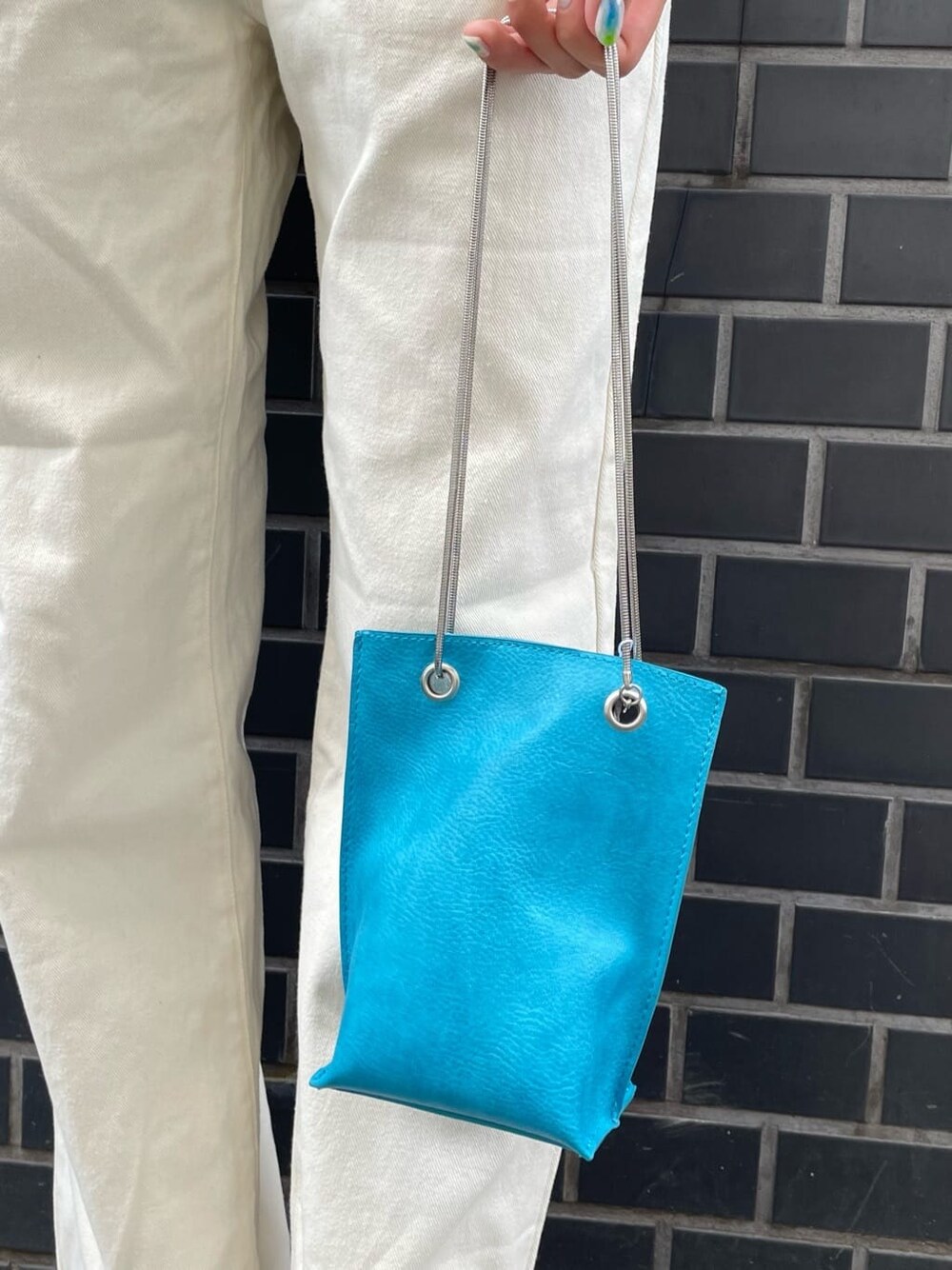 ホワイト系のデニムパンツ、ホワイト系のサンダル、グレー系のニット/セーターを着用したレディースの夏コーディネートの6枚目の写真