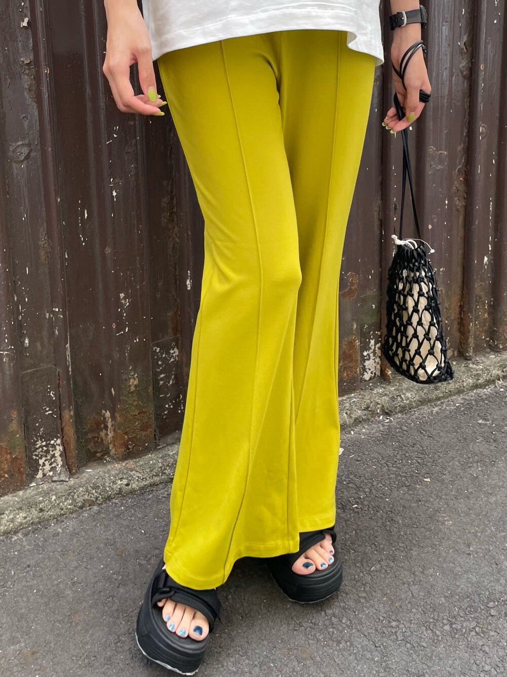 ブラック系のサンダル、ブラック系のハンドバッグ、ホワイト系のTシャツ/カットソーを着用したレディースの春コーディネートの6枚目の写真