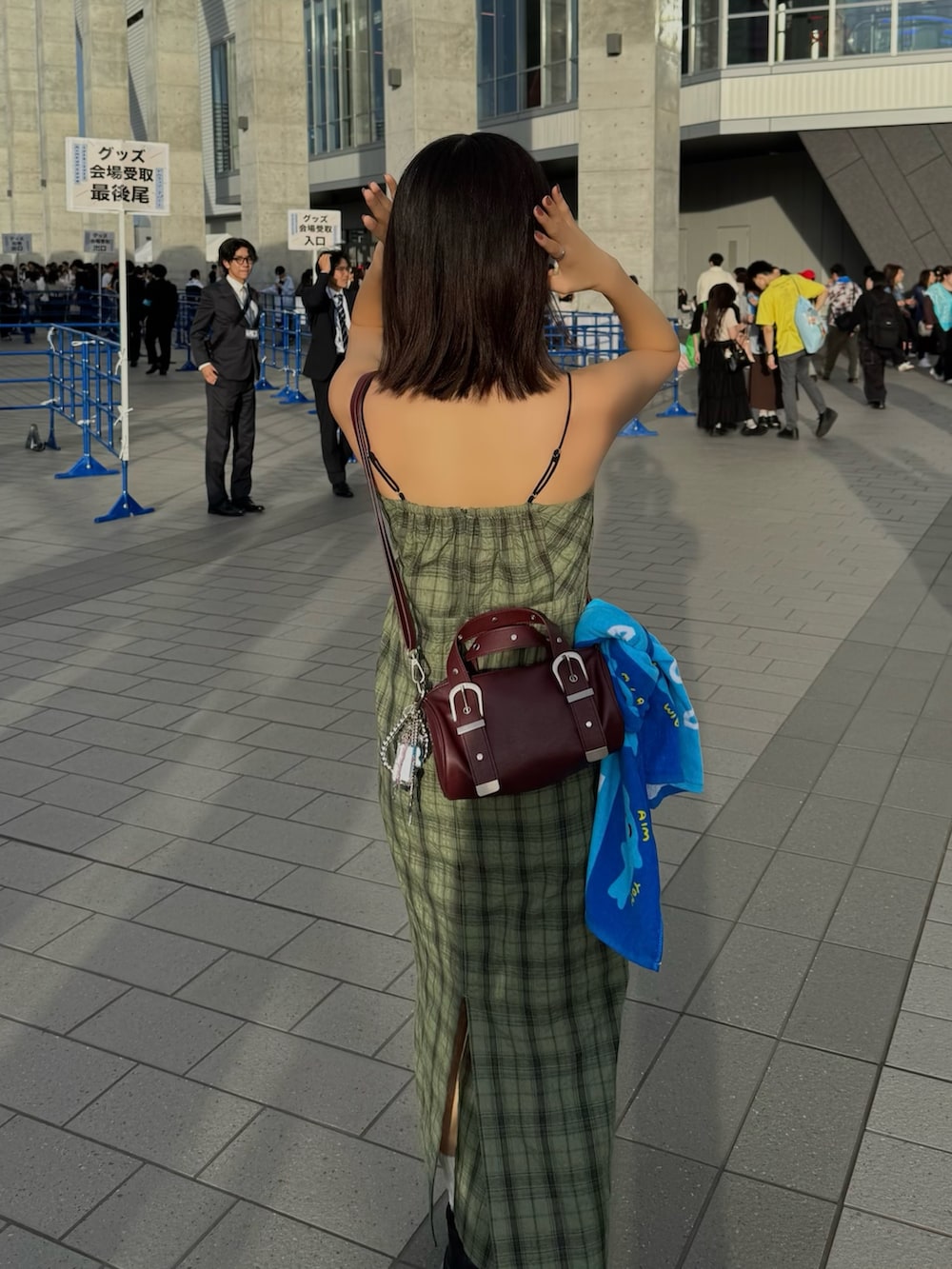 グリーン系のワンピース、レッド系のハンドバッグを着用したレディースの春コーディネートの3枚目の写真