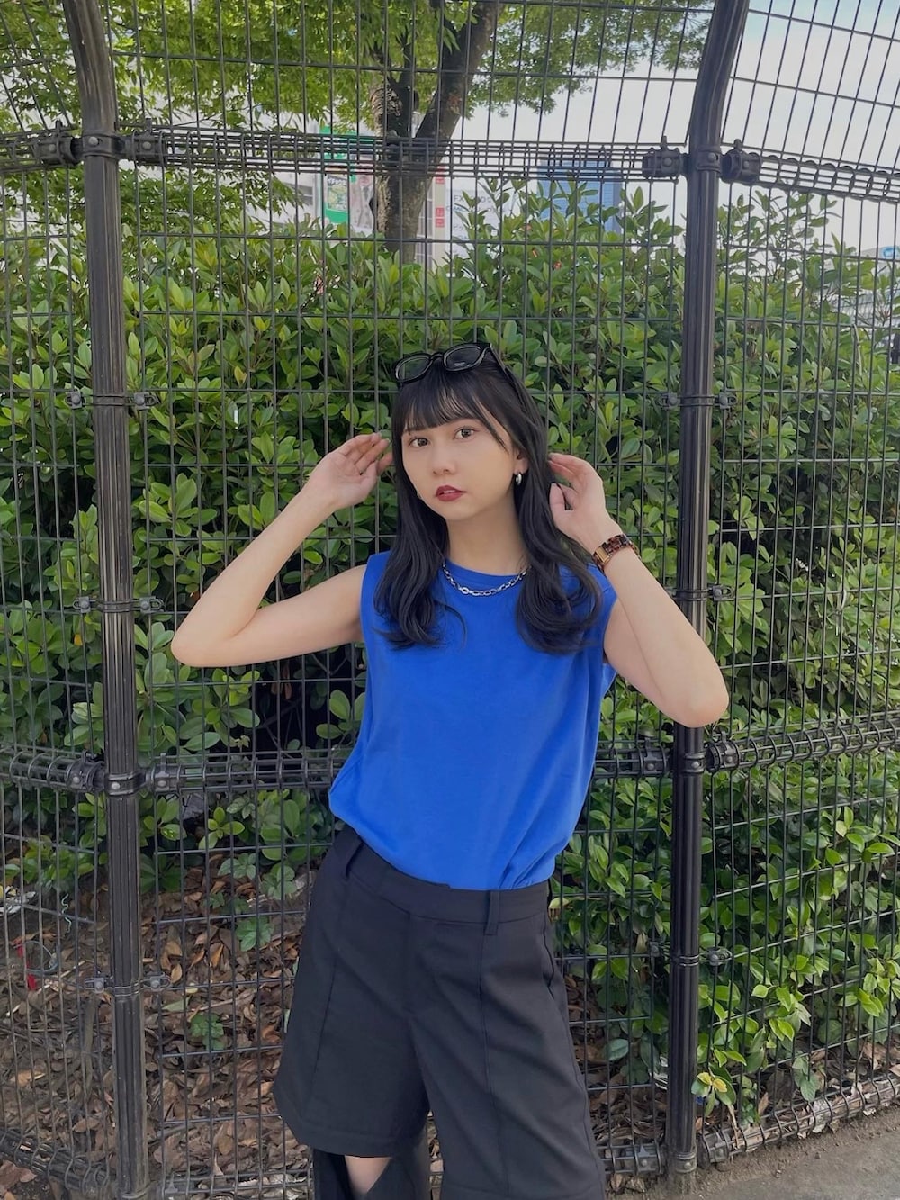 ブルー系のTシャツ/カットソー、ブラック系のスラックス、ブラック系のサンダルを着用したレディースの春コーディネートの3枚目の写真
