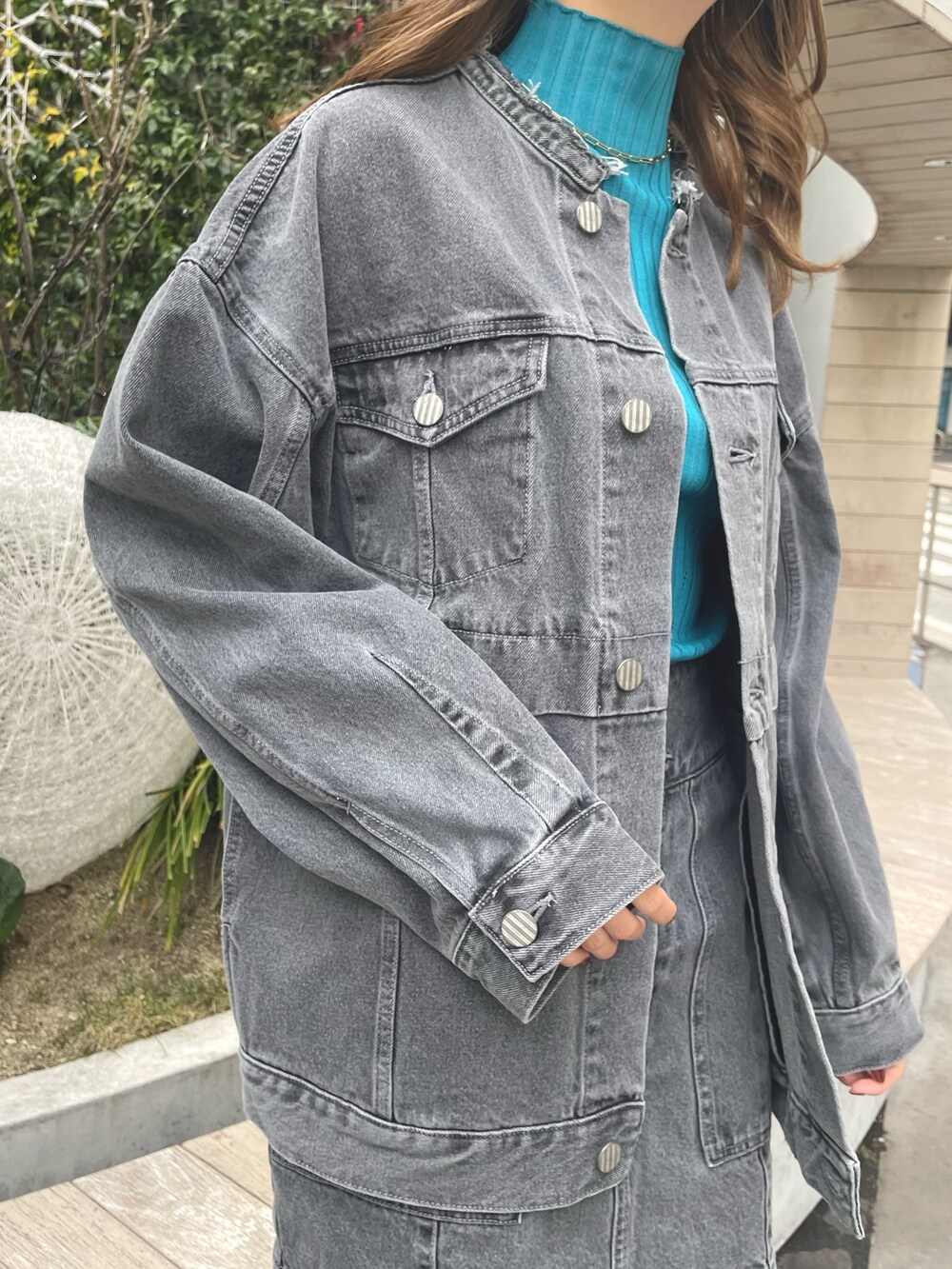 グレー系のデニムジャケット、グレー系のスカート、ブラック系のブーツを着用したレディースの冬コーディネートの6枚目の写真