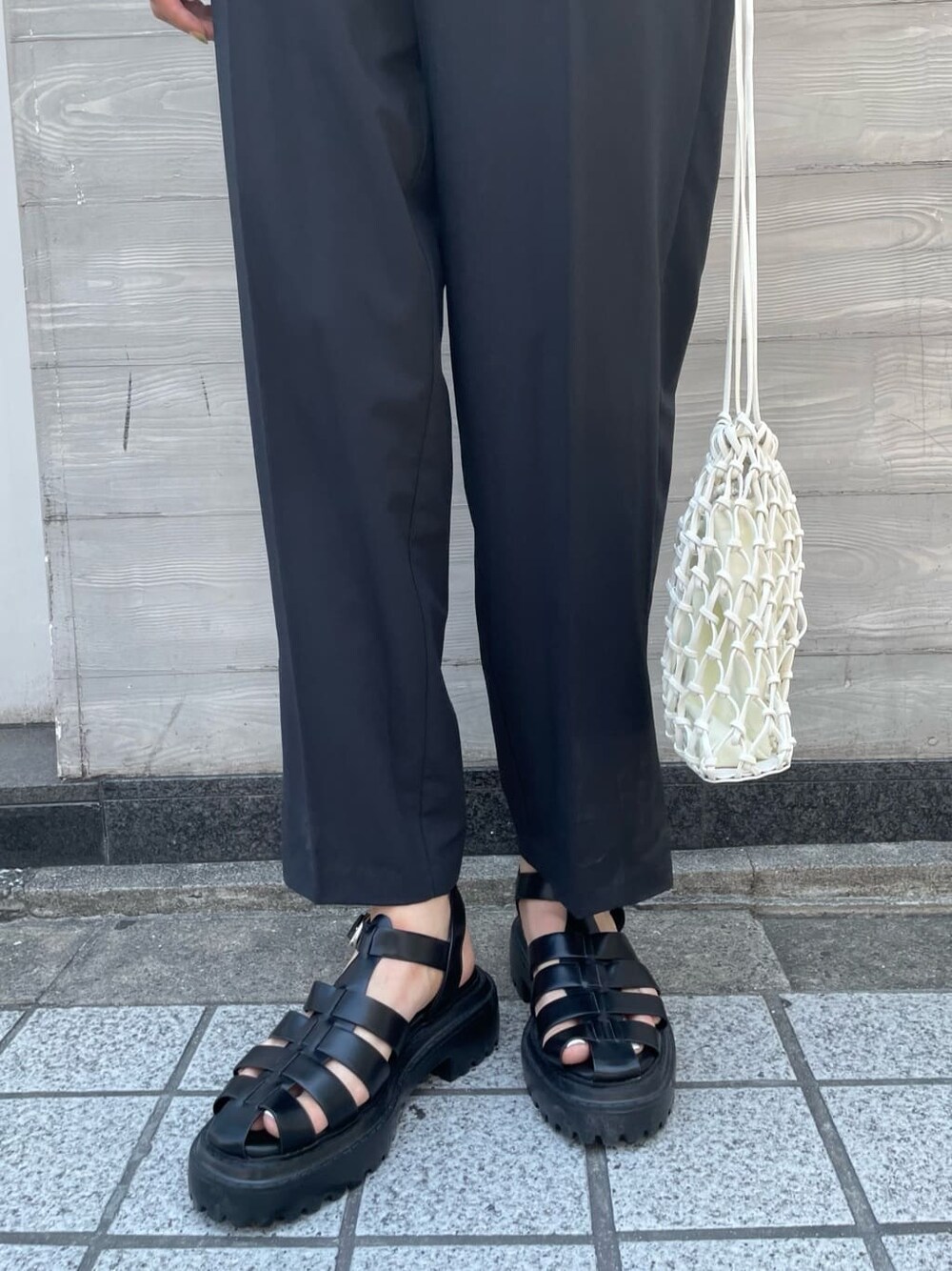 ホワイト系のハンドバッグ、ブラック系のつなぎ/オールインワン、ブラック系のサンダルを着用したレディースの夏コーディネートの6枚目の写真