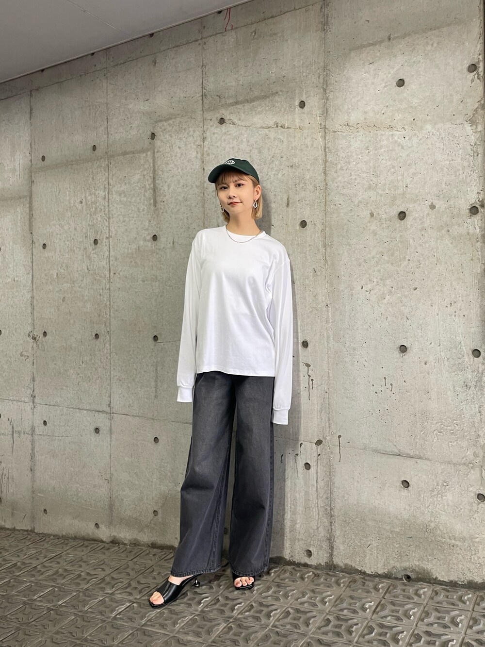 ブラック系のサンダル、ブラック系のデニムパンツ、ホワイト系のTシャツ/カットソーを着用したレディースの冬コーディネートの3枚目の写真