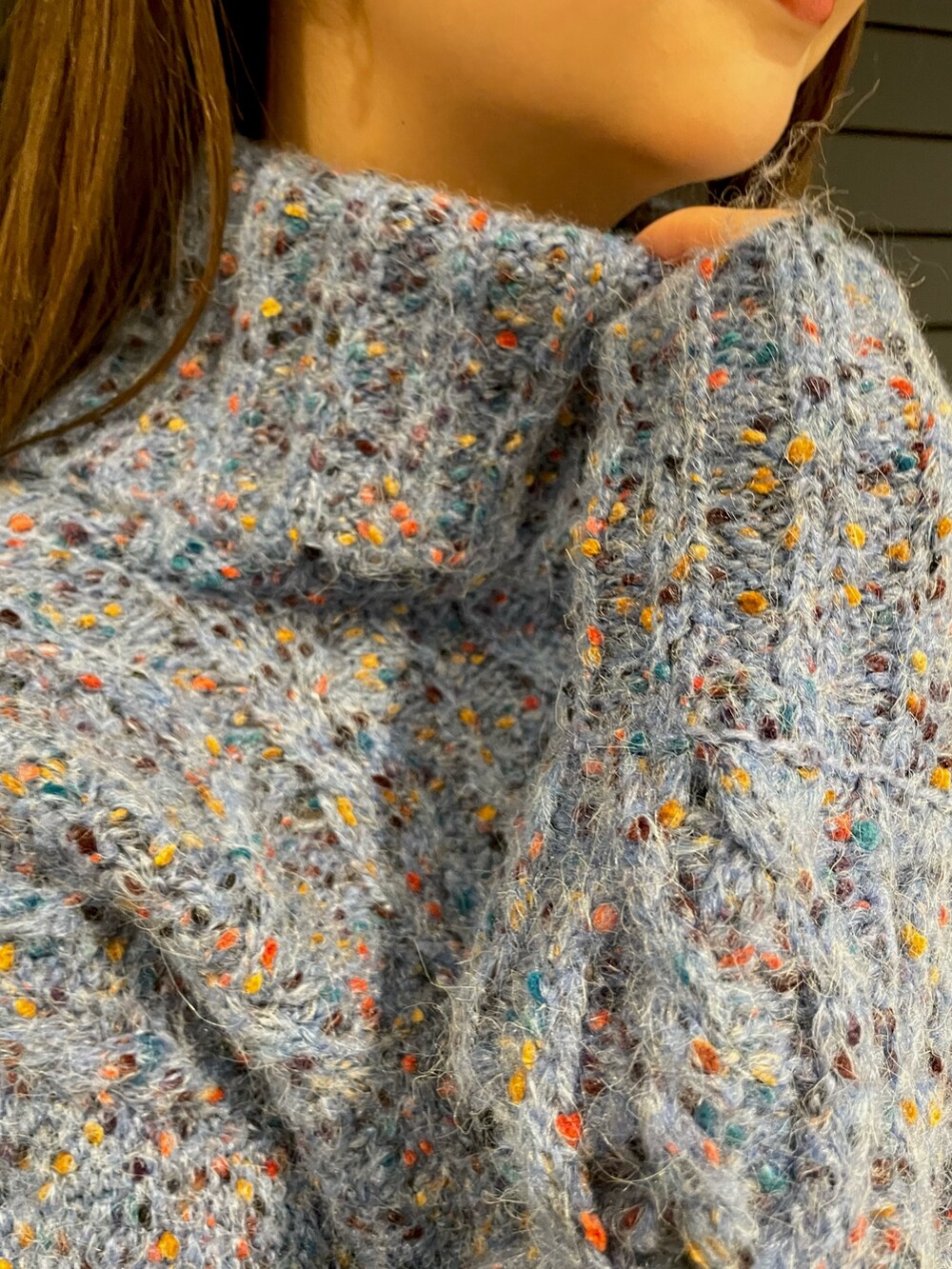 ブルー系のニット/セーター、ブラック系のハンドバッグ、ブラック系のブーツを着用したレディースの冬コーディネートの6枚目の写真