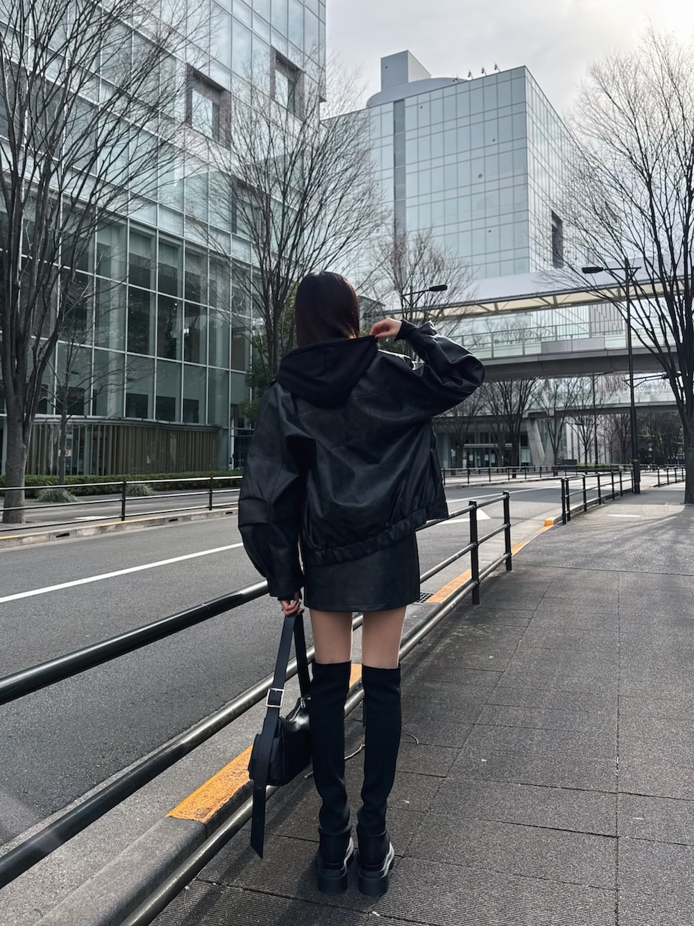 ブラック系のブルゾン、ブラック系のパーカー、ブラック系のブーツを着用したレディースの冬コーディネートの3枚目の写真