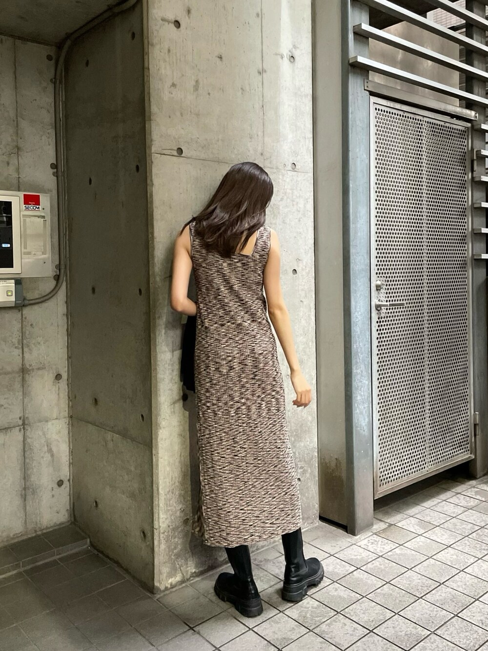 ブラック系のテーラードジャケット、ブラウン系のワンピースを着用したレディースの春コーディネートの3枚目の写真