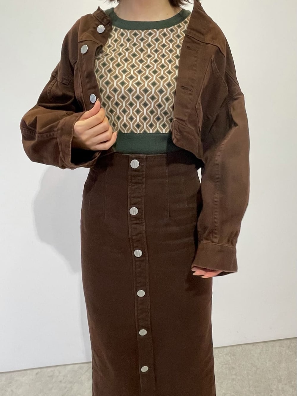 ブラウン系のブルゾン、ブラウン系のスカート、ホワイト系のブーツを着用したレディースの秋コーディネートの3枚目の写真