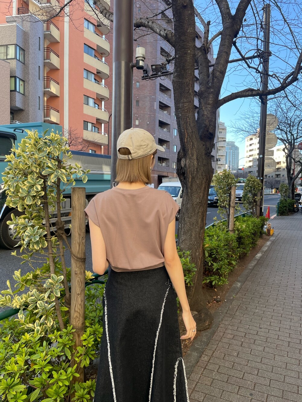 ブラウン系のTシャツ/カットソー、シルバー系のブーツ、ブラック系のデニムスカートを着用したレディースの冬コーディネートの4枚目の写真