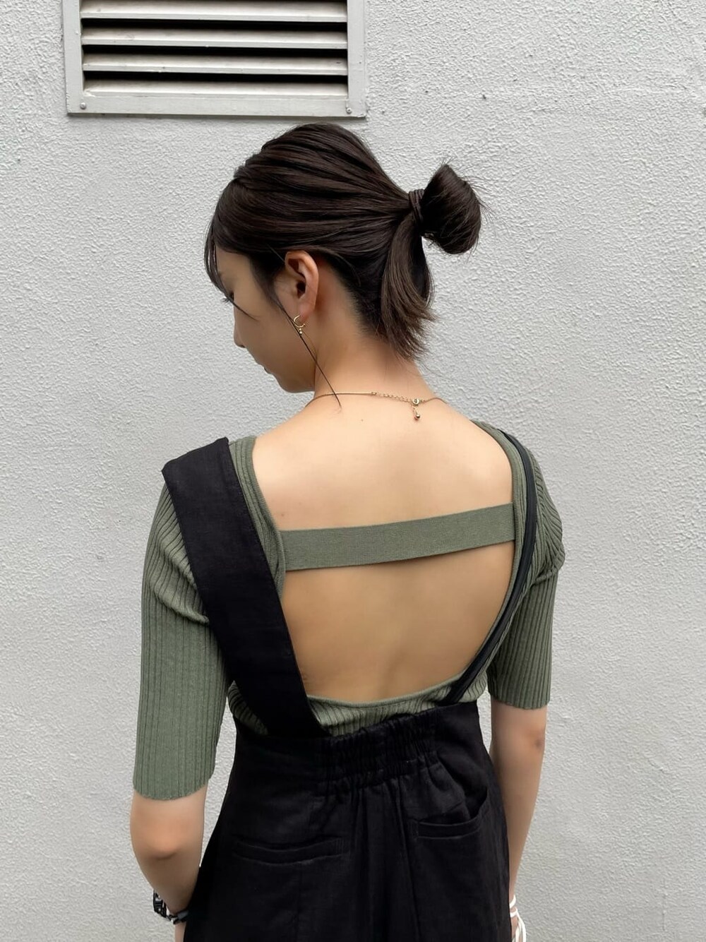 ブラック系のつなぎ/オールインワン、ホワイト系のハンドバッグ、グリーン系のニット/セーターを着用したレディースの春コーディネートの6枚目の写真